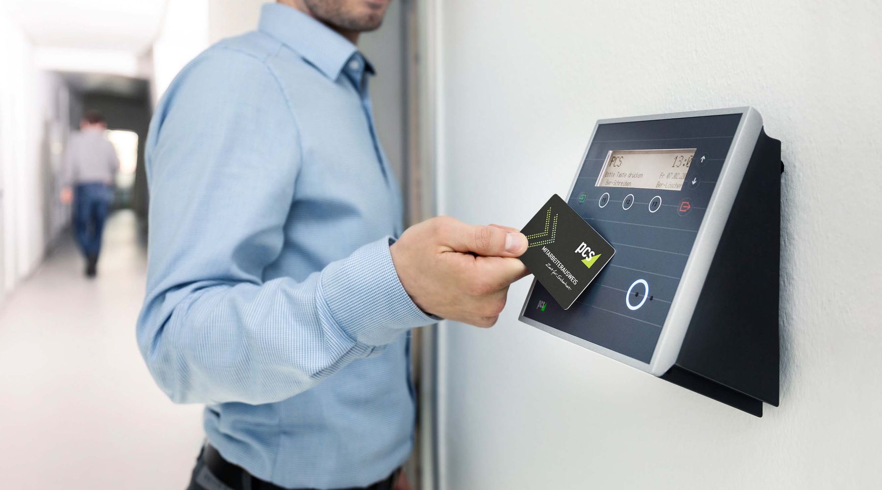 A person holding an access card to a door reader