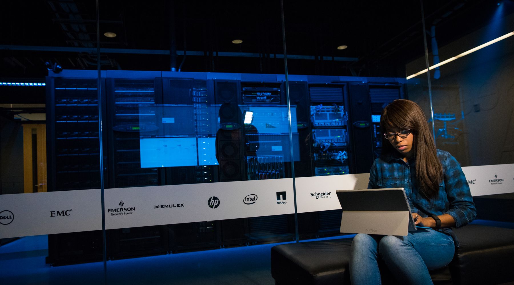 An engineer using a laptop between server racks